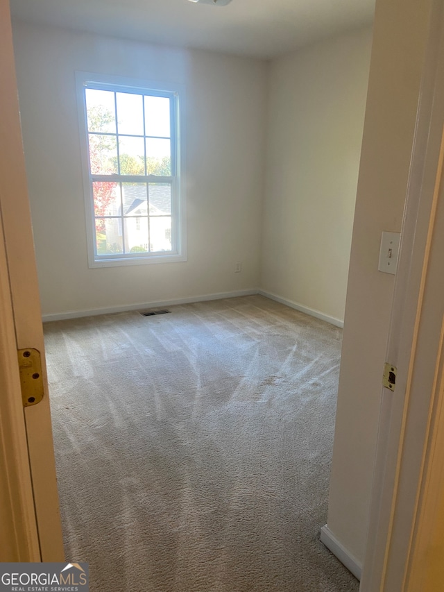 unfurnished room with light carpet