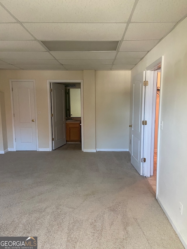 carpeted empty room featuring a drop ceiling