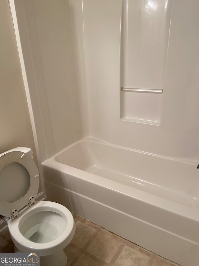 bathroom with toilet, tile patterned floors, and bathing tub / shower combination