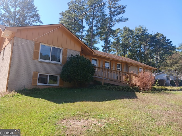 back of property featuring a wooden deck and a lawn