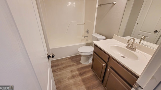 full bathroom featuring hardwood / wood-style floors, vanity, toilet, and  shower combination