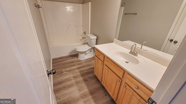 full bathroom featuring wood-type flooring, bathing tub / shower combination, toilet, and vanity