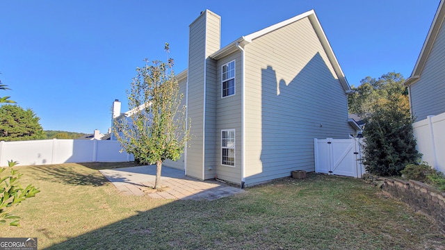 rear view of house with a lawn and a patio