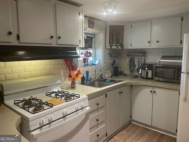 kitchen with decorative backsplash, dark hardwood / wood-style floors, exhaust hood, sink, and white appliances