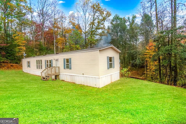 rear view of property featuring a lawn