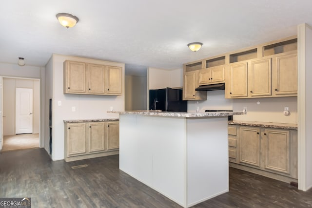 kitchen featuring black fridge, dark wood-type flooring, a kitchen island, and light brown cabinets