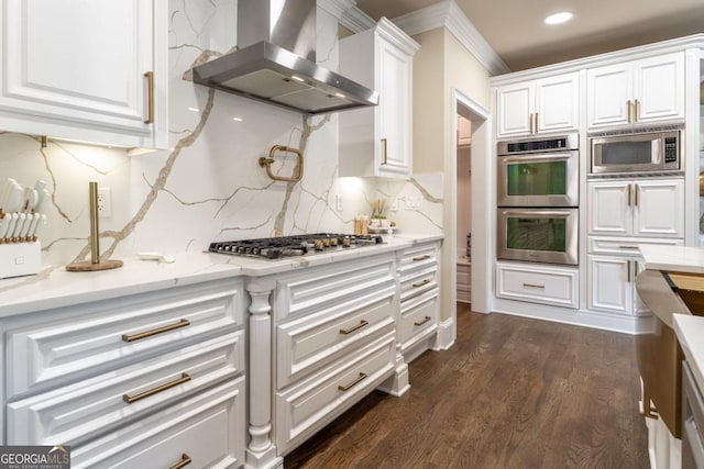 kitchen featuring wall chimney range hood, white cabinets, backsplash, dark hardwood / wood-style floors, and stainless steel appliances