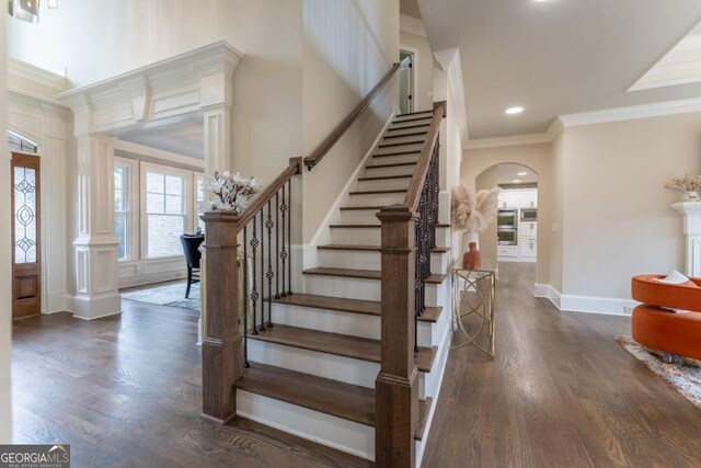 foyer entrance with ornamental molding and dark hardwood / wood-style floors