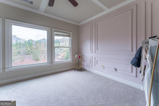 carpeted empty room with ornamental molding, ceiling fan, and a wealth of natural light