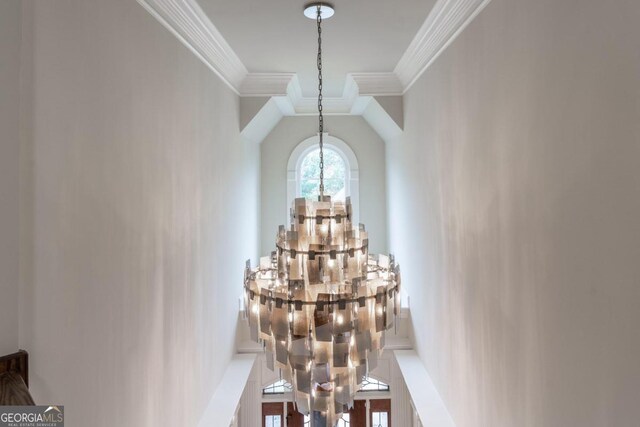 interior details featuring ornamental molding and an inviting chandelier