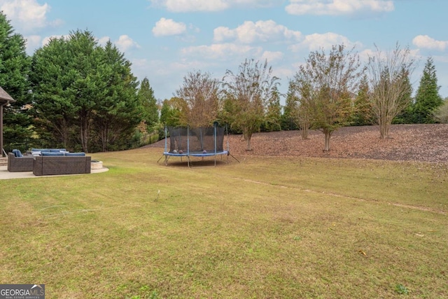 view of yard with a trampoline and outdoor lounge area