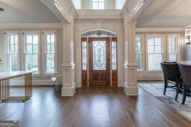 foyer with decorative columns, ornamental molding, plenty of natural light, and dark hardwood / wood-style flooring