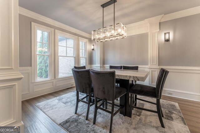 dining space featuring ornamental molding and dark wood-type flooring