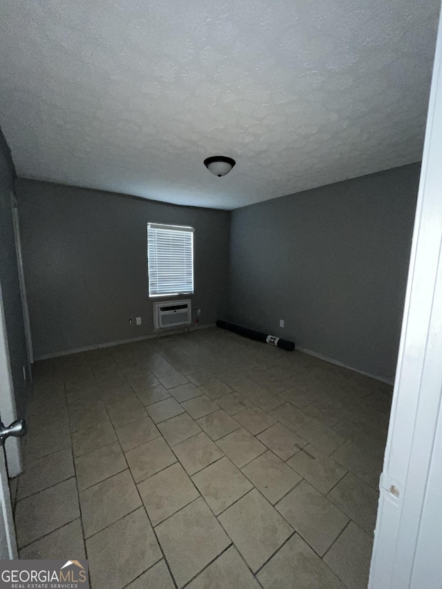 121-123 E King Ave, Kingsland, GA 31548 - unfurnished room featuring a textured ceiling, a wall mounted AC, baseboards, and light tile patterned flooring