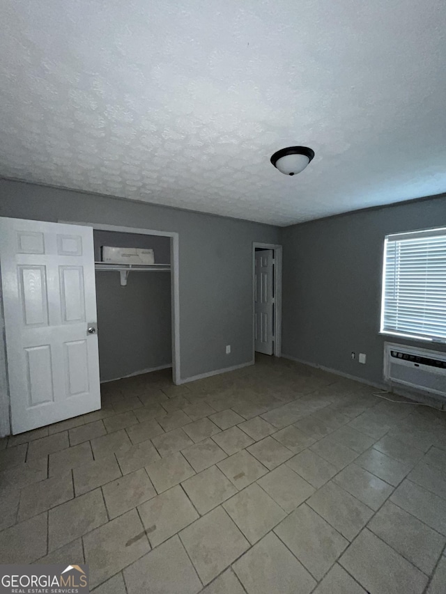 121-123 E King Ave, Kingsland, GA 31548 - tiled spare room with baseboards, a wall mounted AC, and a textured ceiling