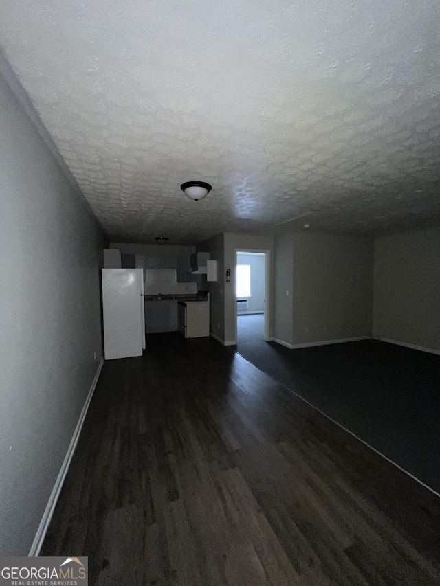121-123 E King Ave, Kingsland, GA 31548 - unfurnished living room featuring dark wood finished floors, a textured ceiling, and baseboards