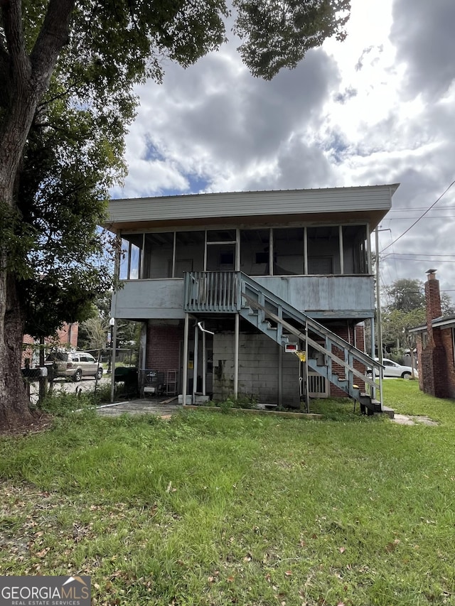 121-123 E King Ave, Kingsland, GA 31548 - back of house with a lawn, stairs, and a sunroom