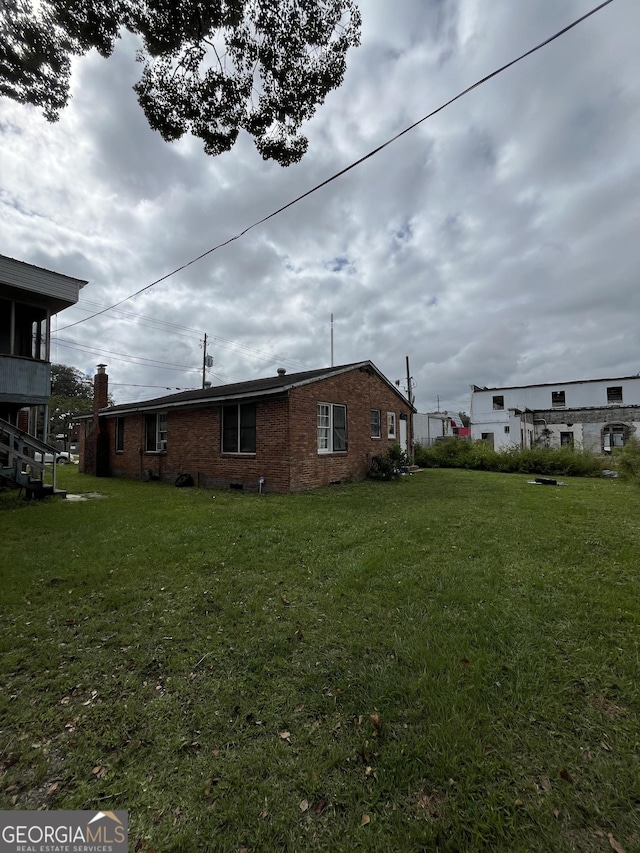 121-123 E King Ave, Kingsland, GA 31548 - view of home's exterior featuring brick siding and a yard
