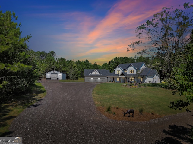 view of front of property with an outdoor structure, a lawn, and a garage