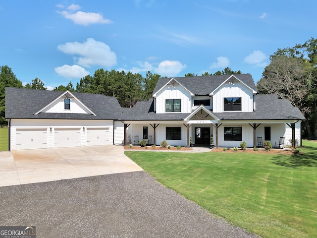 modern inspired farmhouse with a front lawn, covered porch, and a garage