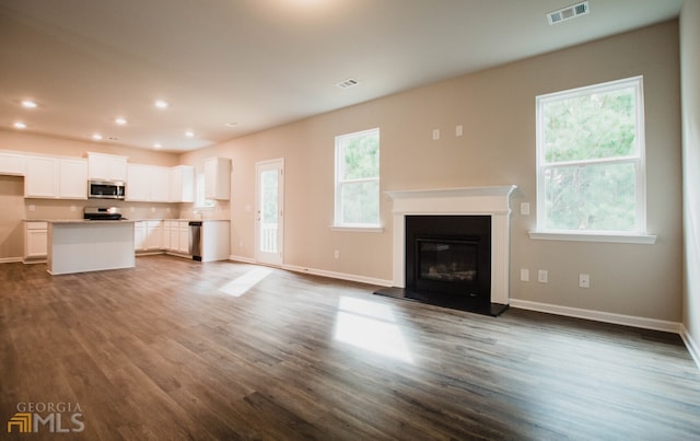 unfurnished living room featuring sink and dark hardwood / wood-style flooring