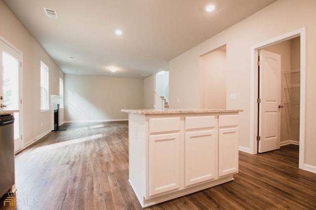 kitchen with white cabinetry, hardwood / wood-style flooring, and a kitchen island