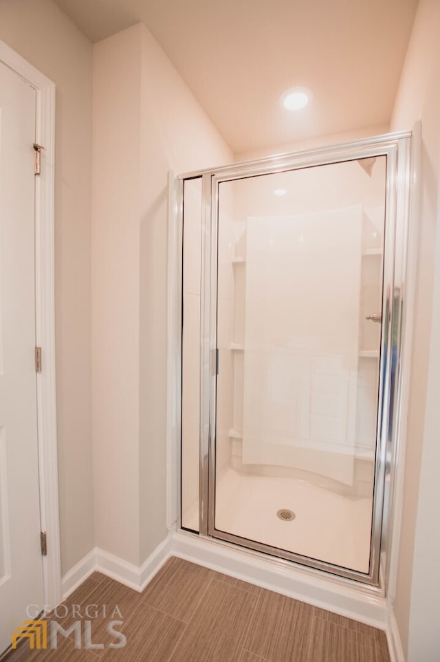 bathroom featuring a shower with door