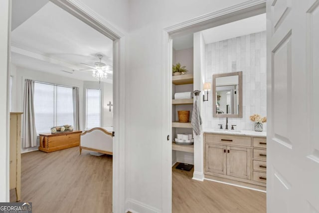 interior space featuring backsplash, ceiling fan, hardwood / wood-style floors, and vanity