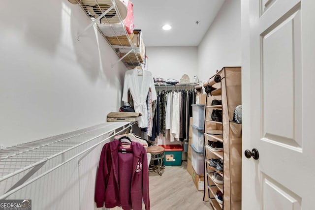 walk in closet with light hardwood / wood-style flooring