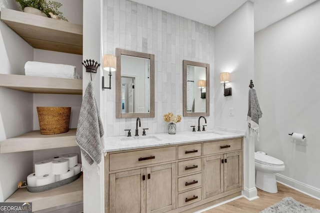 bathroom featuring backsplash, hardwood / wood-style flooring, vanity, and toilet