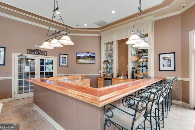 bar with french doors, butcher block countertops, hanging light fixtures, and crown molding