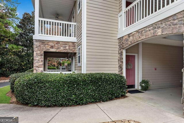 property entrance with a balcony and ceiling fan