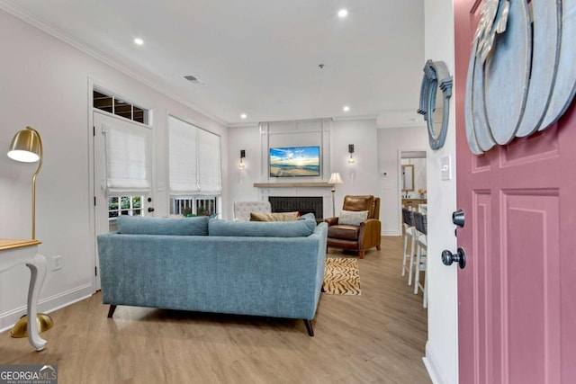 living room with light hardwood / wood-style floors and ornamental molding