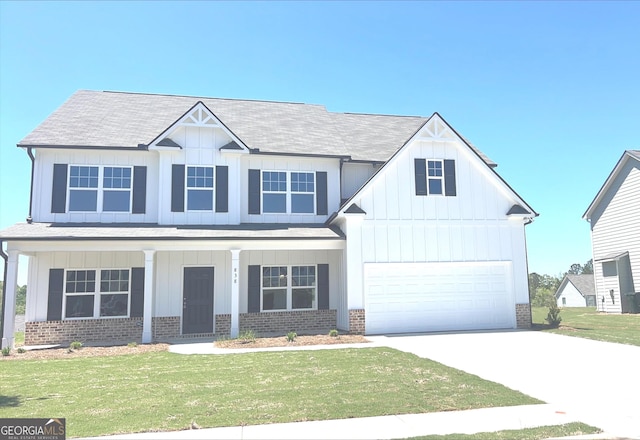 view of front facade with a front yard, a garage, and a porch