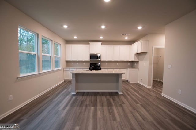 kitchen featuring an island with sink, dark hardwood / wood-style floors, and white cabinets