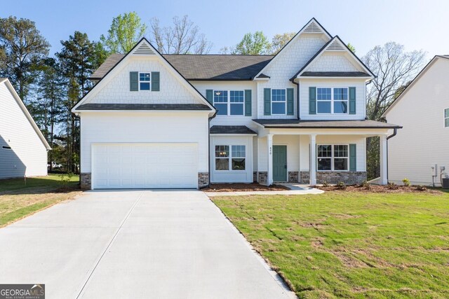 470 River Run Dr Unit 63, Dallas, GA 30132 - view of front facade featuring driveway, a front yard, an attached garage, and stone siding