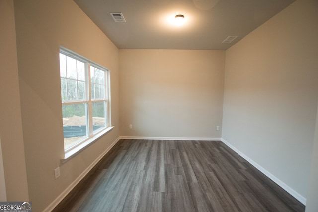 spare room with dark wood-type flooring