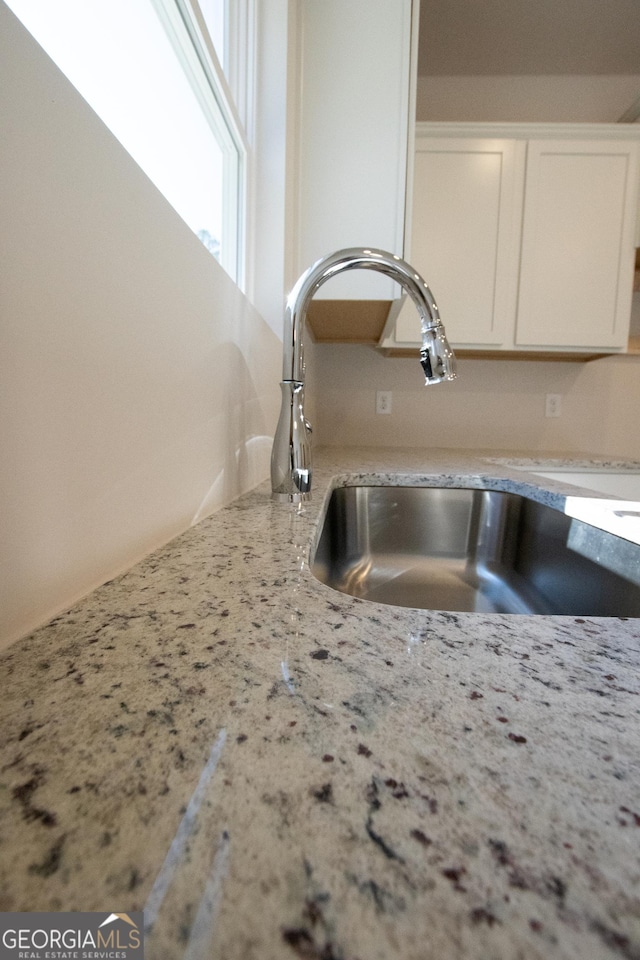 530 River Run Dr Unit 58, Dallas, GA 30132 - kitchen view of a sink, white cabinetry, and light stone counters