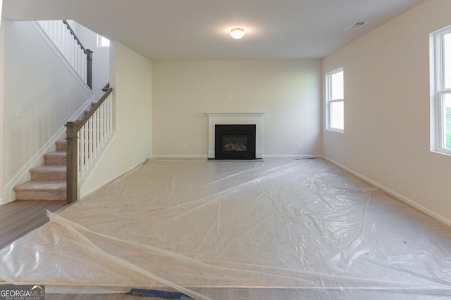 530 River Run Dr Unit 58, Dallas, GA 30132 - unfurnished living room with stairway, a glass covered fireplace, and baseboards
