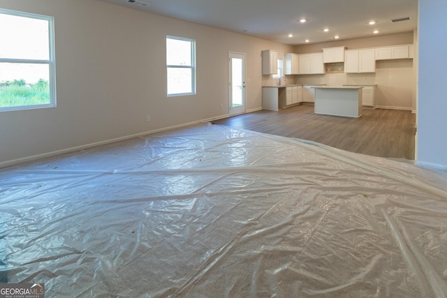 530 River Run Dr Unit 58, Dallas, GA 30132 - unfurnished living room featuring baseboards, light wood-style flooring, recessed lighting, and a sink