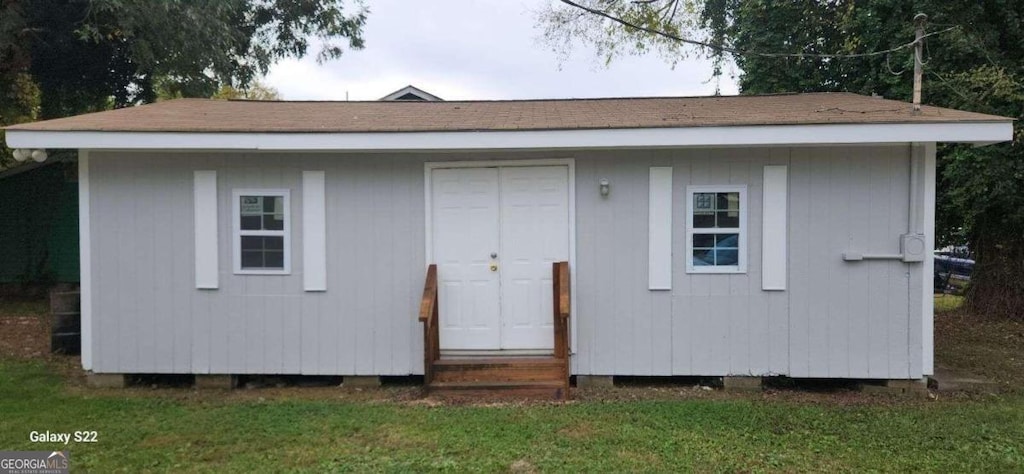 view of outbuilding featuring a lawn