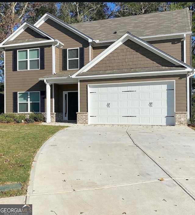 craftsman inspired home with a garage and a front lawn