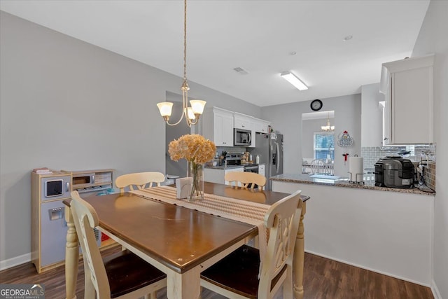 dining space featuring a chandelier and dark hardwood / wood-style floors