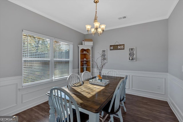 dining room featuring dark wood-type flooring, crown molding, and a notable chandelier