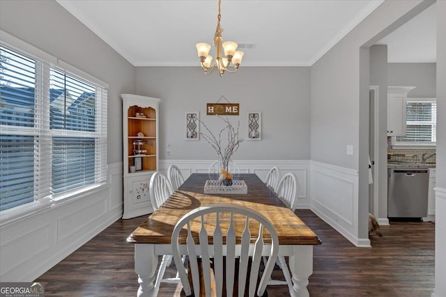 dining area featuring dark hardwood / wood-style floors, ornamental molding, and an inviting chandelier