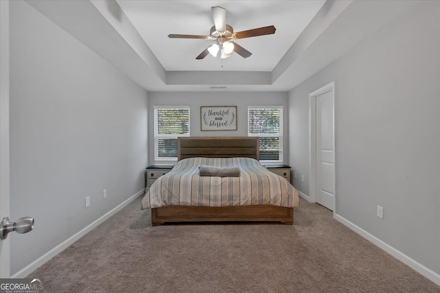 unfurnished bedroom with carpet, a tray ceiling, and ceiling fan