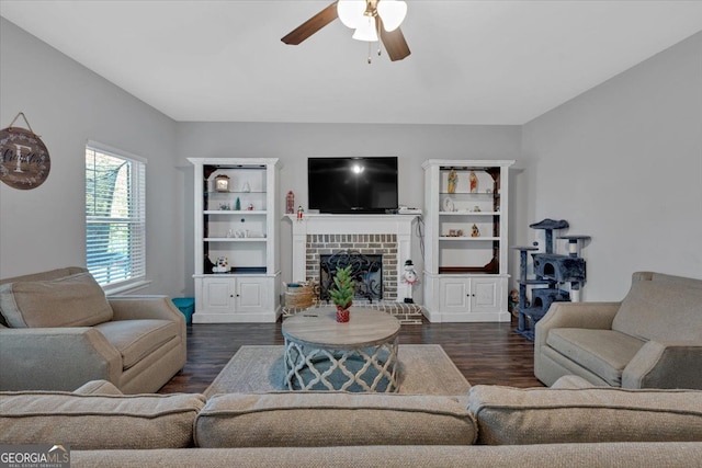 living room featuring a fireplace, ceiling fan, and dark wood-type flooring