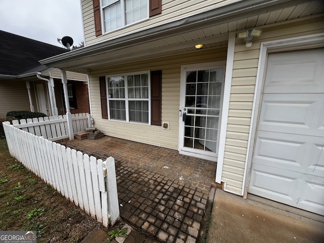 view of patio featuring a porch and a garage