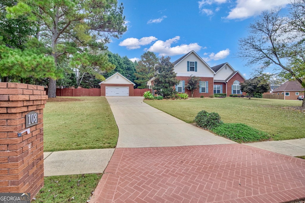 view of front of house with a garage, a front yard, and an outbuilding