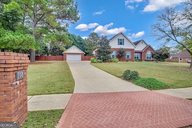 view of front of house with a garage, a front yard, and an outbuilding